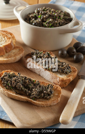 Nero oliva tapenade sul pane francese tostato Foto Stock