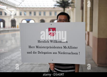 Bassa Sassonia il primo ministro David McAllister (CDU) viene accolto con un grande segno presso la stazione ferroviaria a Qingdao, Cina, 8 luglio 2010. McAllister intende visitare la provincia dello Shandong e l'Expo di Shanghai durante il fine settimana con una delegazione per l economia della Bassa Sassonia. Foto: Jochen Lübke Foto Stock