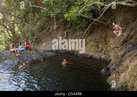 Oscillazione su una corda swing alla cascata di Montezuma, Playa Montezuma, Puntarenas Provincia, Costa Rica. Foto Stock