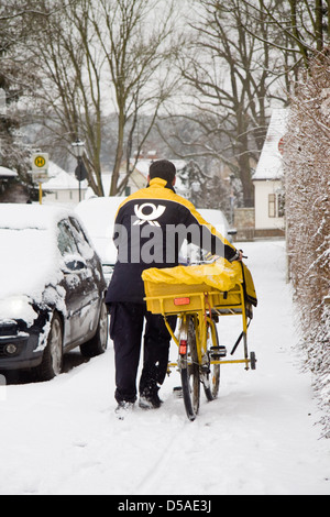 Berlino, Germania, un postino nella neve sulla strada Foto Stock