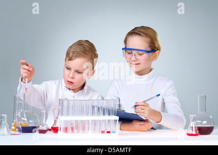 Entusiasta il ragazzo e ragazza a sperimentare e a scrivere i risultati Foto Stock