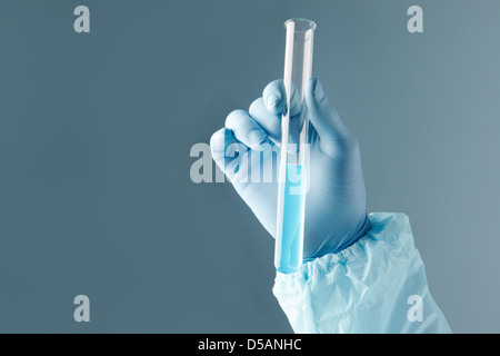 Close-up immagine di una mano umana in possesso di una provetta con sostanza blu Foto Stock