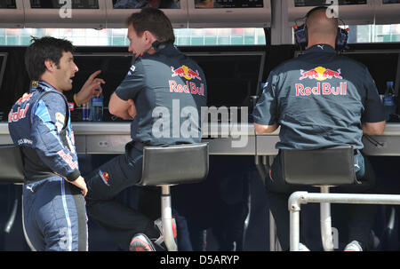 Der australische Formel-1-Rennfahrer Mark Webber von Red Bull spricht am Samstag (10.07.2010) wŠhrend des dritten formazione auf der Rennstrecke a Silverstone in Inghilterra im Kommandostand Mit einem Techniker. Am Wochenende avviato mit dem Gro§en Preis von Gro§britannien das zehnte Rennen der Formel-1-Saison 2010. Foto: Carmen Jaspersen dpa Foto Stock