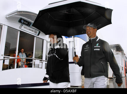 Il driver tedesco Michael Schumacher di Mercedesa GP (R) e la sua portavoce Sabine Kehm (L) a piedi attraverso il paddock del circuito di Hockenheim di Hockenheim, in Germania, 22 luglio 2010. Il 2010 di Formula 1 Gran Premio di Germania che si svolgerà il 25 luglio. Foto: Jens BUETTNER Foto Stock