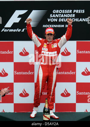 Driver spagnolo Fernando Alonso della Scuderia Ferrari solleva il trofeo per la vincita del 2010 di Formula 1 Gran Premio di Germania sul circuito di Hockenheim di Hockenheim, in Germania, il 25 luglio 2010. Foto: Ronald Wittek Foto Stock