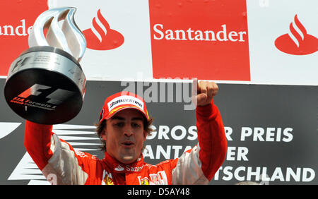 Driver spagnolo Fernando Alonso della Scuderia Ferrari solleva il trofeo per la vincita del 2010 di Formula 1 Gran Premio di Germania sul circuito di Hockenheim di Hockenheim, in Germania, il 25 luglio 2010. Foto: Carmen Jaspersen Foto Stock