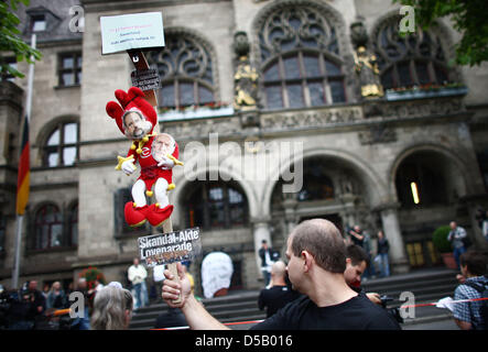 Un dimostrante contiene fino una bambola su un bastone di fronte al municipio di Duisburg, 29 luglio 2010. 200 persone hanno chiesto il sindaco di Sauerland di rassegnare le dimissioni e commemorano le vittime in un minuto di silenzio. Il 24 luglio 2010, 21 morti e centinaia di feriti durante una massa panico alla techno music festival Love Parade. Foto: Oliver Berg Foto Stock