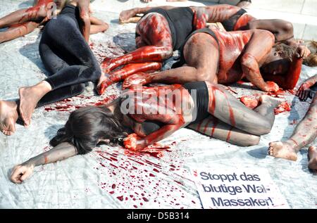 Colorate e coperte di sangue finto, Peta-attivisti si trovano di fronte all'Ambasciata Danese di Berlino, Germania, 5 agosto 2010. Dipinta come alalonga Balene Pilota, attivisti dei diritti degli animali organizzazione PETA Germania dimostrare contro il sloughter di alalonga galles pilota sulle Isole Faeroer. Foto: Rainer Jensen Foto Stock