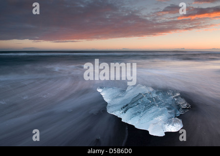 Filamento blocco di ghiaccio si è incagliata su una spiaggia di sabbia. Jökulsarlon Glacier Bay, a sud dell'Islanda. Foto Stock