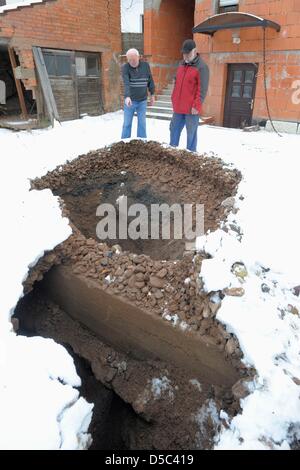 28.01.10/Erneut Erdfall in Tiefenort. Rund um den Betonpfropfen rutscht die Erde in die Tiefe. Grundstücksnachbarn schauen den Schaden un./ Heiko Matz Hauptstraße 108 36433 Bad Salzungen Tel. 0173/3903163 matzfoto@t-online.de Veröffentlichung honorarpflichtig (7%) Mehrwertsteuer Veröffentlichung nur mit Namensnennung  Bankverbindung: VR-Bank Bad Salzungen-Schmalkalden Kto. Foto Stock