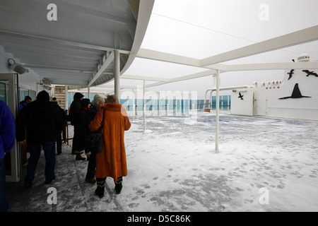 I passeggeri sul ponte aperto di crociera artico con copertura di neve Norvegia europa Foto Stock