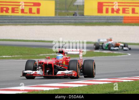 Marzo 22, 2013, Sepang, Malesia - Fernando Alonso, spagnolo la Scuderia Ferrari driver di Formula Uno (anteriore) sterzo la sua vettura durante la prima sessione di prove libere di Formula Uno Malaysian Grand Prix 2013 al Sepang International Circuit. (Foto di Robertus Pudyanto/AFLO) Foto Stock