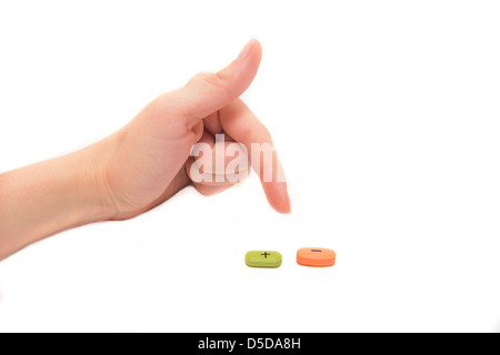 Compresse con plus e il segno meno e mano femmina isolato su bianco. Concetto di scelta. Foto Stock