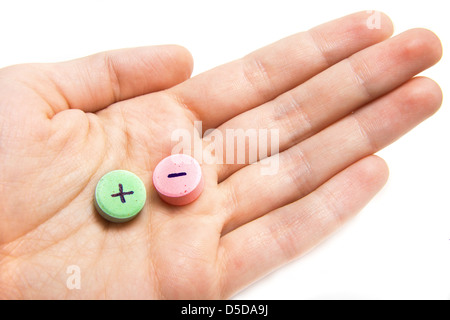 Compresse con plus e il segno meno e mano femmina isolato su bianco. Concetto di scelta. Foto Stock