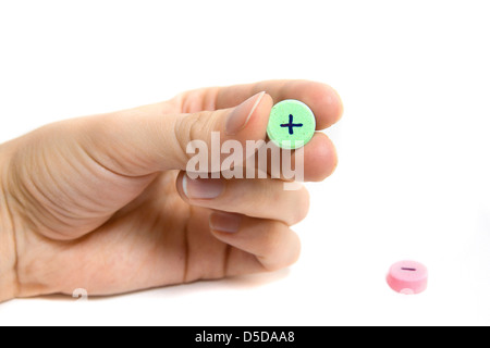 Compresse con plus e il segno meno e mano femmina isolato su bianco. Concetto di scelta. Foto Stock
