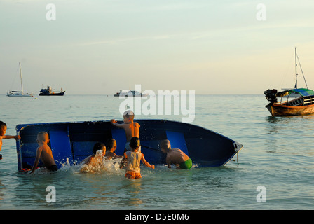 Bambini che giocano come la luce si affievolisce veloce sull isola di Lipe Satun in Thailandia il 8/11/2012 Foto Stock