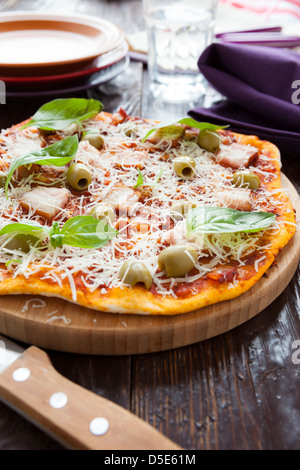 La pizza fatta in casa con pancetta sulla scheda e il coltello, primo piano Foto Stock