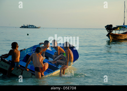 Bambini che giocano su lipe island come la luce si affievolisce veloce. Isola di Lipe satun Thailandia prese il 11/08/2012 Foto Stock