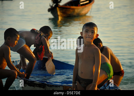 Bambini che giocano su lipe island come la luce si affievolisce veloce. Isola di Lipe satun Thailandia prese il 11/08/2012 Foto Stock