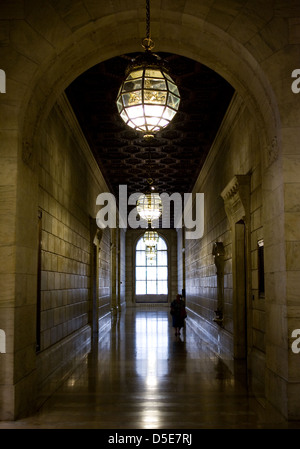 Un vecchio corridoio di pietra nella Biblioteca Pubblica di New York con grandi lampadari Foto Stock