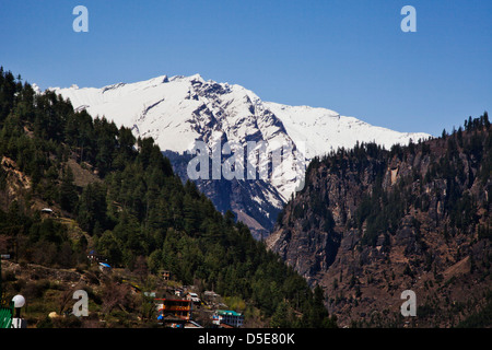 Città con montagne coperte di neve in background, Manali, Himachal Pradesh, India Foto Stock