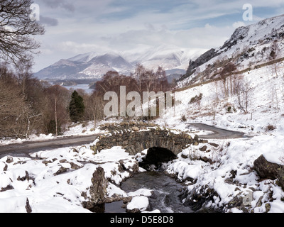Piuttosto Ashness ponte sulla strada da Keswick per la frazione isolata di Watendlath sembra ancora meglio nella neve. Foto Stock
