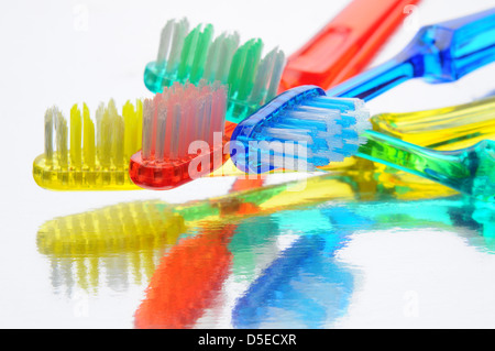 Primo piano di diversi spazzolini da denti recante su una superficie riflettente. Formato orizzontale. Foto Stock