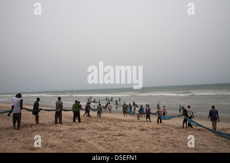 Cala di pescatori una grande rete sulla costa atlantica vicino a Accra, Ghana. Foto Stock