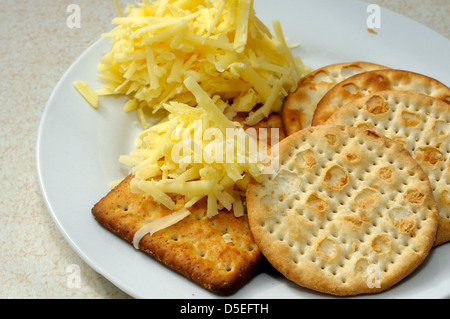 Grattugiato stagionato formaggio Cheddar con cracker Foto Stock