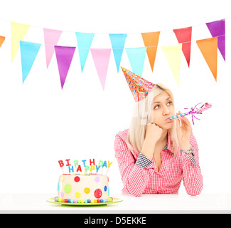 Triste ragazza di compleanno con una torta isolati su sfondo bianco Foto Stock