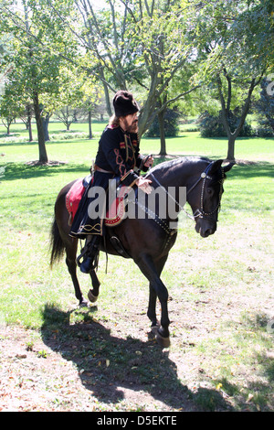 Un russo cosacco in sella ad un cavallo nel campo Foto Stock