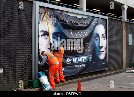 Gli uomini mettendo su affissioni poster, stazione di Coventry, Regno Unito Foto Stock