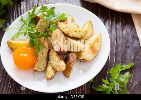 Patate al forno con spicchi di aglio, primo piano Foto Stock