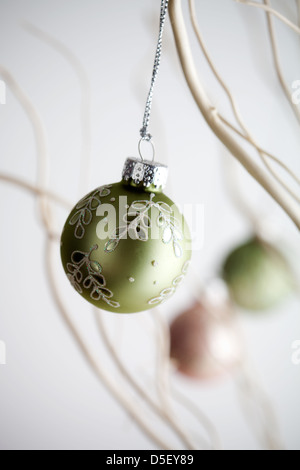 Splendido Natale baubles appesi da rami di bianco Foto Stock