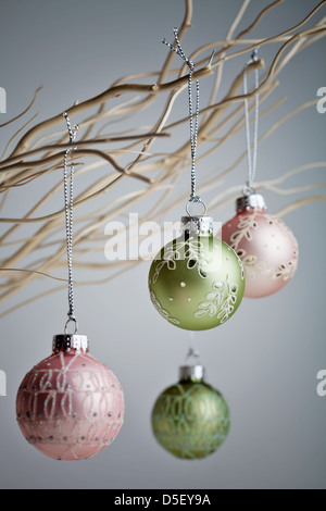 Splendido Natale baubles appesi da rami di bianco Foto Stock