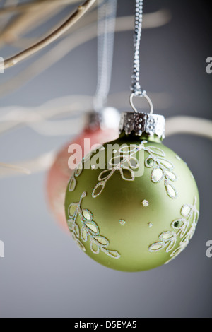 Splendido Natale baubles appesi da rami di bianco Foto Stock