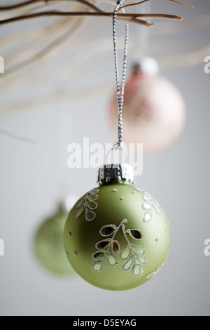 Splendido Natale baubles appesi da rami di bianco Foto Stock