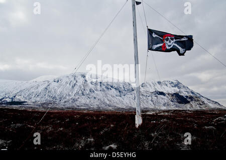 Glencoe, UK. Il 31 marzo 2013.Il cranio e crossbones sventola a metà al di sopra del montante il Glencoe mountain resort nelle Highlands della Scozia in segno di rispetto per la mancanza di un fondista che si è avventurato fuori pista ed è stato catturato in una valanga di ieri. Foto Stock