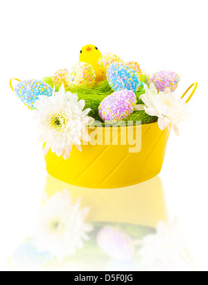 Belle le uova colorate con pulcino dolce in festa cesto giallo isolato su sfondo bianco, tradizionale simbolo di Pasqua Foto Stock
