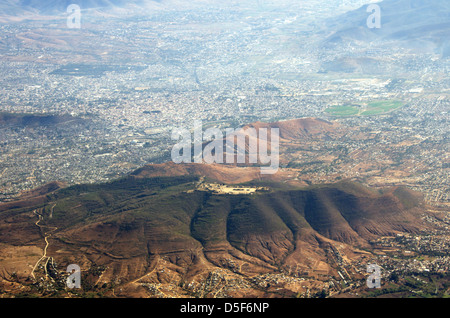 Vista aerea delle rovine di Monte Alban (sulla sommità della collina) con la città di Oaxaca de Juarez, Messico diffondere intorno a loro. Foto Stock