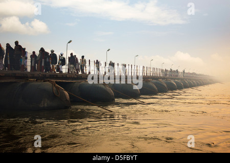 I pellegrini che, attraversando il ponte durante il primo royal bath processione in Kumbh Mela Festival, di Allahabad, Uttar Pradesh, India Foto Stock