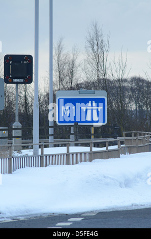 Inizio dell'autostrada M1 a firmare circondato da gigante derive di neve nelle vicinanze Leeds Yorkshire Regno Unito Foto Stock