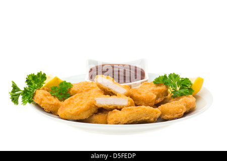Pepite di pollo con le fette di limone e un barbecue dip, servita su un piatto e pronto da mangiare - sfondo bianco Foto Stock