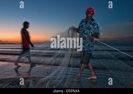 I pescatori al tramonto a Nadi spiaggia di fronte al Tropico del Capricorno e Smugglers Cove Beach Resort Foto Stock