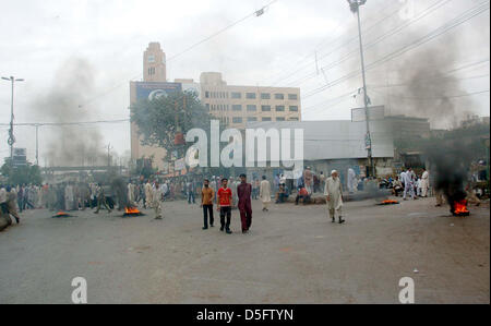 Manifestanti arrabbiati bruciare pneumatici stradali di blocco durante la manifestazione di protesta dei residenti di Kharadar contro il funzionamento mirato dai rangers funzionari, in area torre a Karachi. Foto Stock