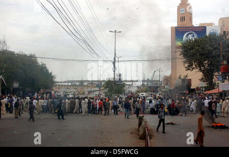 Manifestanti arrabbiati bruciare pneumatici stradali di blocco durante la manifestazione di protesta dei residenti di Kharadar contro il funzionamento mirato dai rangers funzionari, in area torre a Karachi. Foto Stock