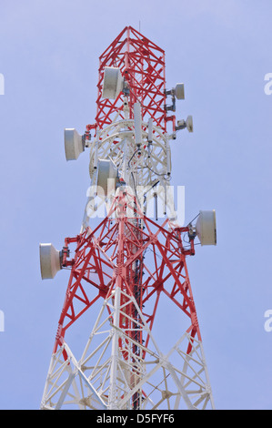 Torre di telecomunicazioni antenna con molti piatti di microonde per la trasmissione di microonde dipinto in rosso e bianco segnale a colori Foto Stock