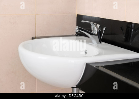 Ceramica Moderna lavabo con acqua cromo rubinetto miscelatore in hotel bagno interno Foto Stock