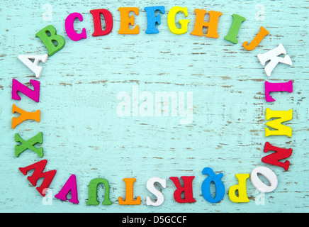 Alfabeto colorato lettere con copia spazio, sulla luce blu sullo sfondo di legno Foto Stock