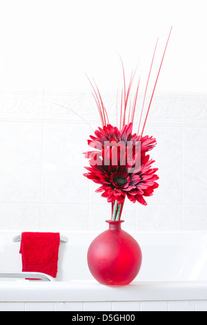 Bagno bianco rosso con asciugamani e fiori Foto Stock